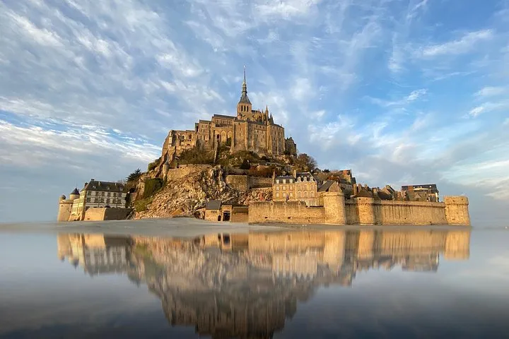 Mont-Saint-Michel island and abbey spire across the bay on a guided day tour from Paris to Mont-Saint-Michel, France