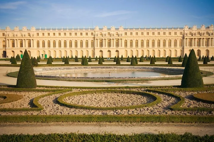 Cyclists riding along the Grand Canal in the Versailles gardens on a bike day tour from Paris to Versailles, France