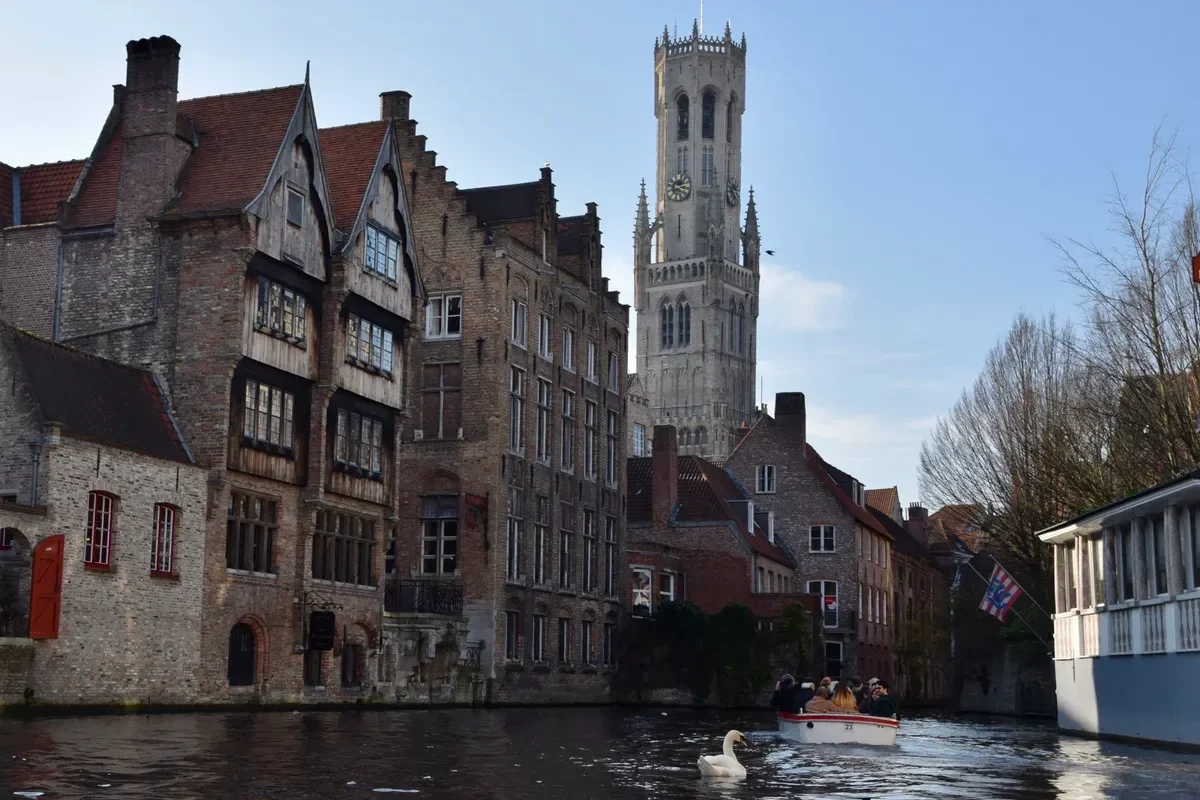 Rozenhoedkaai canal with the Belfry tower in Bruges on a day trip from Paris