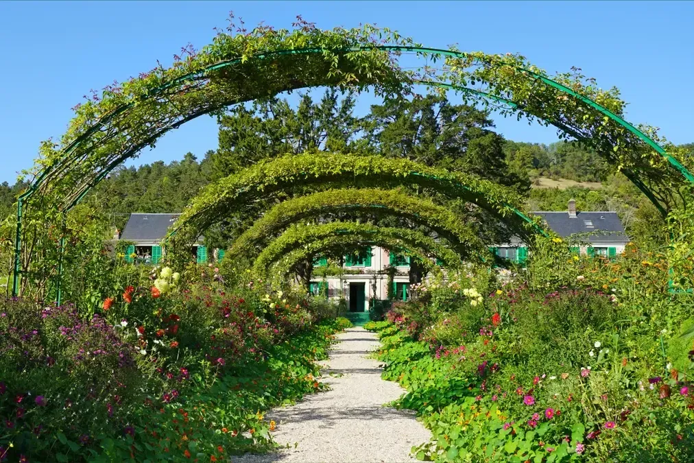 Flower path and arches of the Clos Normand in front of Monet's house on a Giverny and Versailles day trip from Paris